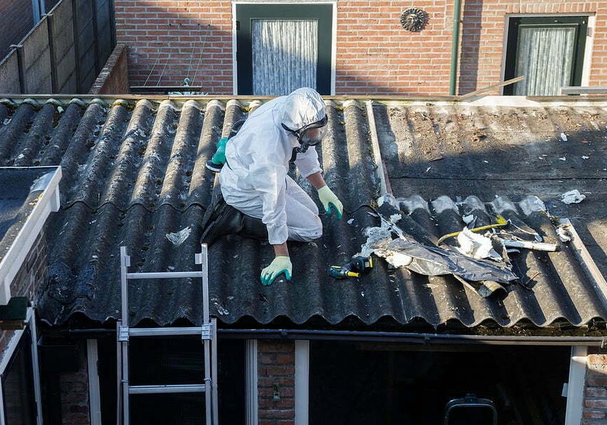 Professional Asbestos Removal. Men In Protective Suit removing asbestos roof tiles Asbestos Tile Removal
